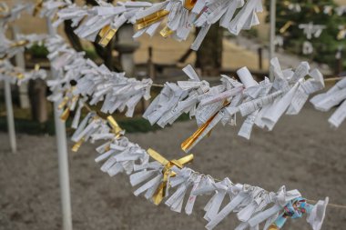 24 Mart 2025 Geleneksel bir Japon tapınağında iplere bağlı kağıt servetler,