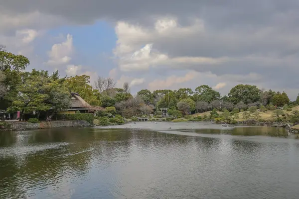 24 Mart 2025 Etrafı yeşil manzaralarla çevrili sakin göl, bahçe ağaçları,