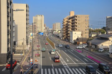 Yüksek binalar ve etkin trafiğin oluşturduğu kalabalık bir şehir caddesinin genel görünümü