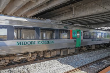 Çağdaş tren etkileyici bir şehir üst geçidinin altındaki istasyon platformunda bekliyor..