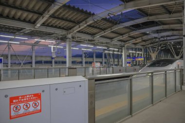 Çağdaş bir tren terminalinin platformu, parlak ve yüksek hızlı bir trenin altını çiziyor