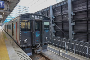 Çağdaş banliyö treni bir şehir tren platformunda konuşlanmıştır.,