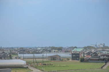 sergilenen yeşil tarım alanları, beyaz seralar, geleneksel evler,