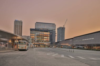 Şehir ulaşım merkezi, park edilmiş otobüsler ve modern binalar.