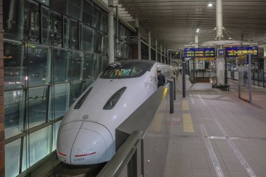 Modern hızlı tren yapay ışık altında istasyona yanaştı.,