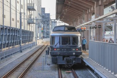 Modern bir yolcu treni küçük bir kırsal kasabadan geçiyor.