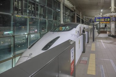 Modern hızlı tren yapay ışık altında istasyona yanaştı.,