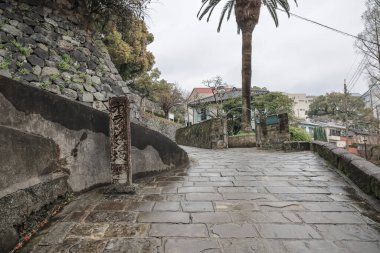 Etrafı taştan bir duvarla çevrili bir yol.