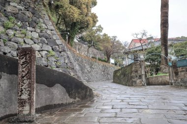 Etrafı taştan bir duvarla çevrili bir yol.