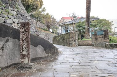 Etrafı taştan bir duvarla çevrili bir yol.