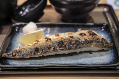 Izgara uskumru filetosu seramik tabakta sunulur.,