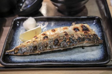 Izgara uskumru filetosu seramik tabakta sunulur.,