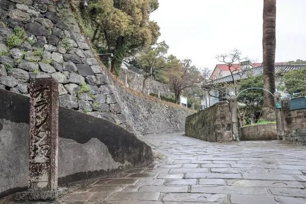 Etrafı taştan bir duvarla çevrili bir yol.