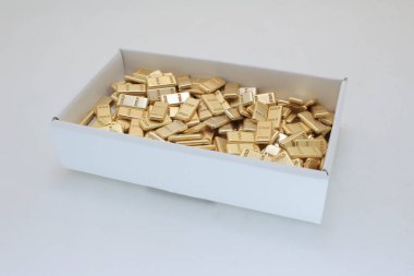 İçinde zenginliği simgeleyen sayısız altın külçeler bulunan beyaz kutu.,