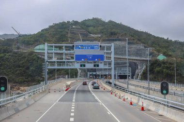 Yüksek bir yol yapısı bir su kütlesini geçiyor, etrafı sarılmış.