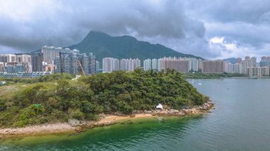 Sakin sularla çevrili yeşil ormanları olan sakin adalar, kentsel gökdelenler