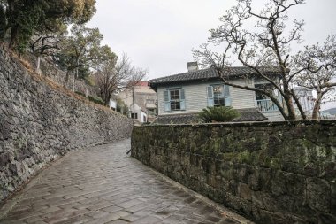 Geleneksel ahşap bir eve giden taştan bir patika.