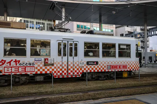 24 Mart 2025 tramvay durakları kalabalık bir şehir ortamında, toplu taşımacılık sergileniyor.