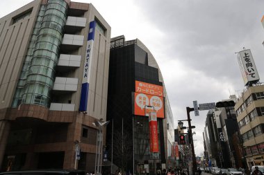 Ticari tabela ve bulutlu gökyüzü altında hareketli yaya etkinliği.