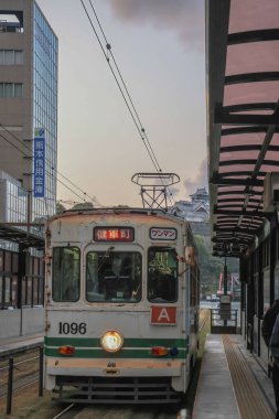 24 Mart 2025 Bir tramvay istasyonu ile hareketli şehir caddesi, banliyö, ve canlı şehir