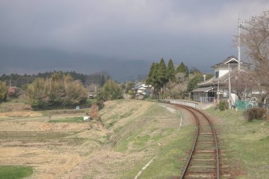 Uzaklara doğru uzanan raylar, açık kanatlarla çevrili.