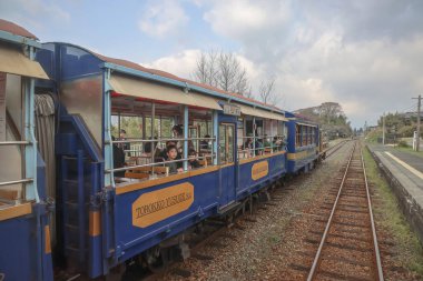 Kırsal bir tren istasyonunda, yolcuların eğlendiği vagonlar.