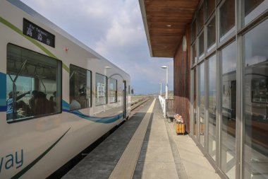 Bir yolcu treni, mimari detaylarla çevrili bir istasyonda durdu.