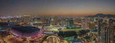 Alacakaranlıkta aydınlanan modern şehir manzarasının panoramik görüntüsü