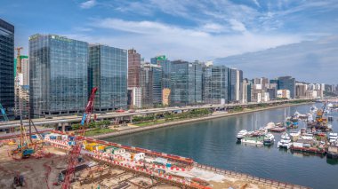 Modern, yükseltilmiş bir otoyolun yer aldığı canlı bir şehir manzarası.