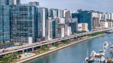 Modern, yükseltilmiş bir otoyolun yer aldığı canlı bir şehir manzarası.