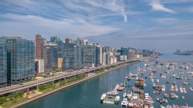 Modern, yükseltilmiş bir otoyolun yer aldığı canlı bir şehir manzarası.