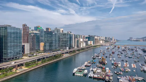 Modern, yükseltilmiş bir otoyolun yer aldığı canlı bir şehir manzarası.