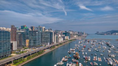 Modern, yükseltilmiş bir otoyolun yer aldığı canlı bir şehir manzarası.