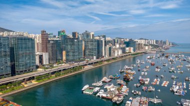 Modern, yükseltilmiş bir otoyolun yer aldığı canlı bir şehir manzarası.