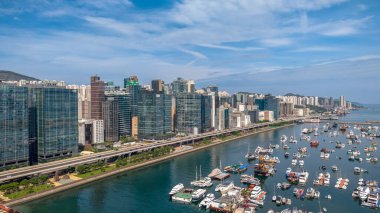 Modern, yükseltilmiş bir otoyolun yer aldığı canlı bir şehir manzarası.