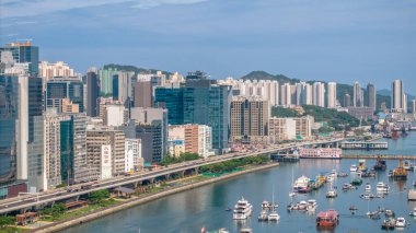 Modern, yükseltilmiş bir otoyolun yer aldığı canlı bir şehir manzarası.