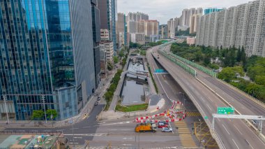 Yüksek gökdelenler, şehir blokları ve yükseltilmiş bir otoyolun yer aldığı canlı şehir manzarası