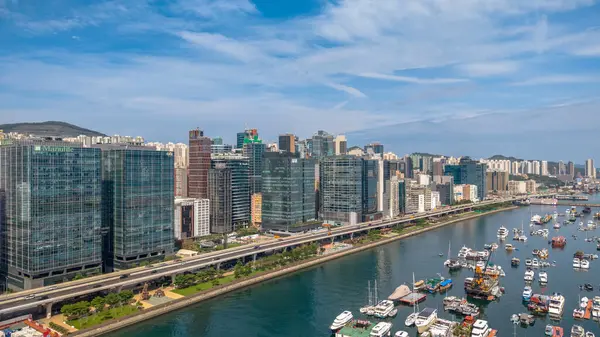 Modern, yükseltilmiş bir otoyolun yer aldığı canlı bir şehir manzarası.