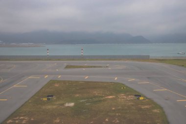 Bulutlu bir günde modern bir havaalanı terminaline park edilmiş uçaklar.