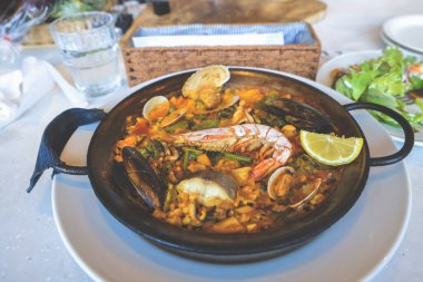 Karidesli paella, midye, pilav ve sebzeli kalamar.