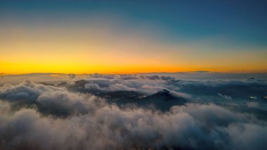 Parlak bir günbatımının altında bulutlu bir şehrin ufuk çizgisini gösteren nefes kesici manzara.