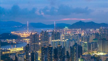 Alacakaranlıkta aydınlanan hareketli bir şehrin çarpıcı hava manzarası.,