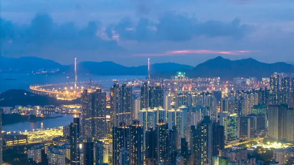 Alacakaranlıkta aydınlanan hareketli bir şehrin çarpıcı hava manzarası.,