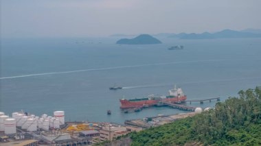 Okyanusun hareketli bir limanının havadan görünüşü rıhtımdaki bir kargo gemisini gösteriyor.