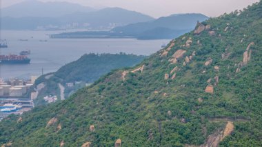 Bir su kütlesi boyunca uzanan asma köprü içeren manzaralı bir manzara.