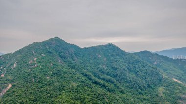 Bir su kütlesi boyunca uzanan asma köprü içeren manzaralı bir manzara.