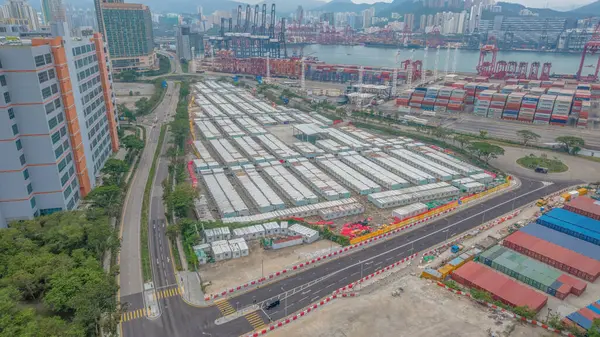 Şehir binaları ve nakliye tesisleriyle çevrili yoğun bir konteyner terminali..