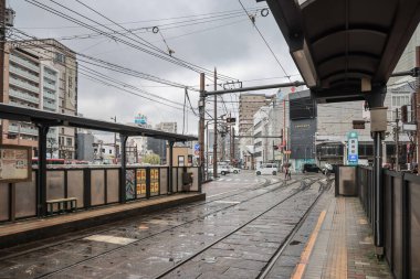 28 Mart 2025 renkli tramvay kalabalık bir şehir bölgesindeki bir istasyonda durdu.