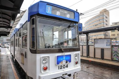 28 Mart 2025 renkli tramvay kalabalık bir şehir bölgesindeki bir istasyonda durdu.