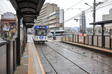 28 Mart 2025 renkli tramvay kalabalık bir şehir bölgesindeki bir istasyonda durdu.